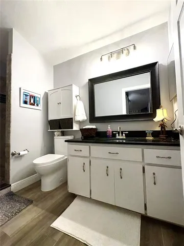 a spacious bathroom with a toilet a sink and a mirror