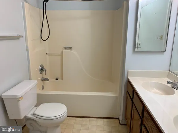 a bathroom with a granite countertop toilet sink and mirror