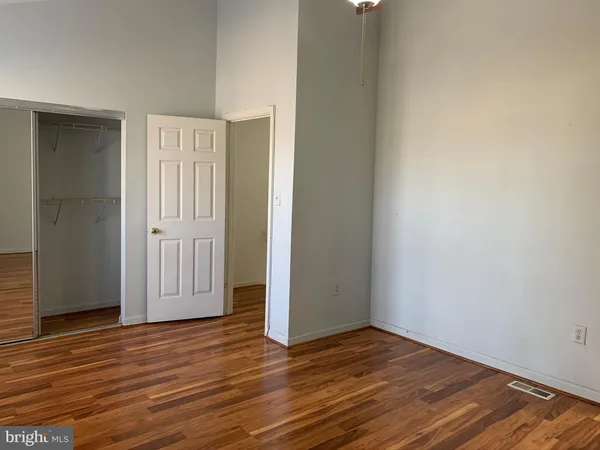 a view of empty room with wooden floor