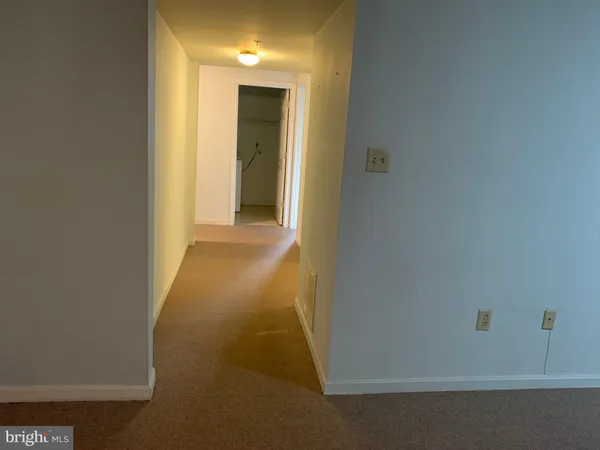 a view of an empty room with painting on the wall and a window