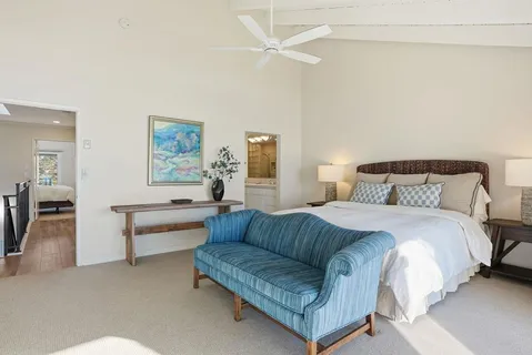 a bedroom with a bed couch and a chandelier
