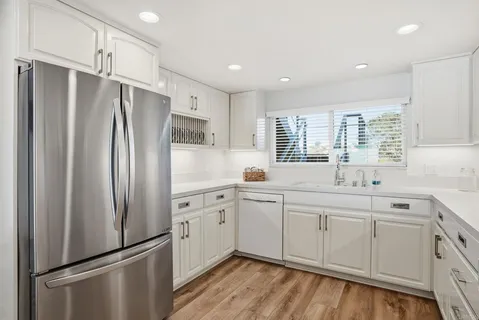 a kitchen with stainless steel appliances a refrigerator sink and cabinets