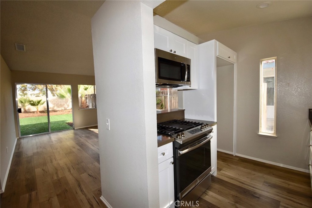 740 Atchison Street Colton, CA 92324 - Photo 12 of 15 a kitchen with a stove a microwave and window