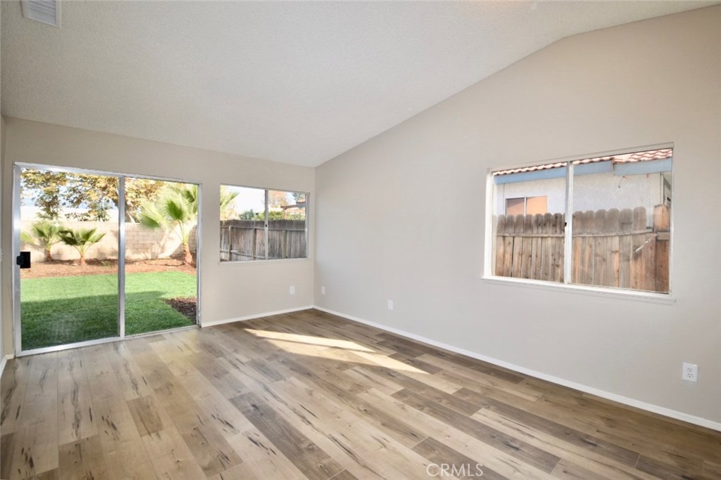 740 Atchison Street Colton, CA 92324 - Photo 2 of 15 a view of an empty room with a window and wooden floor