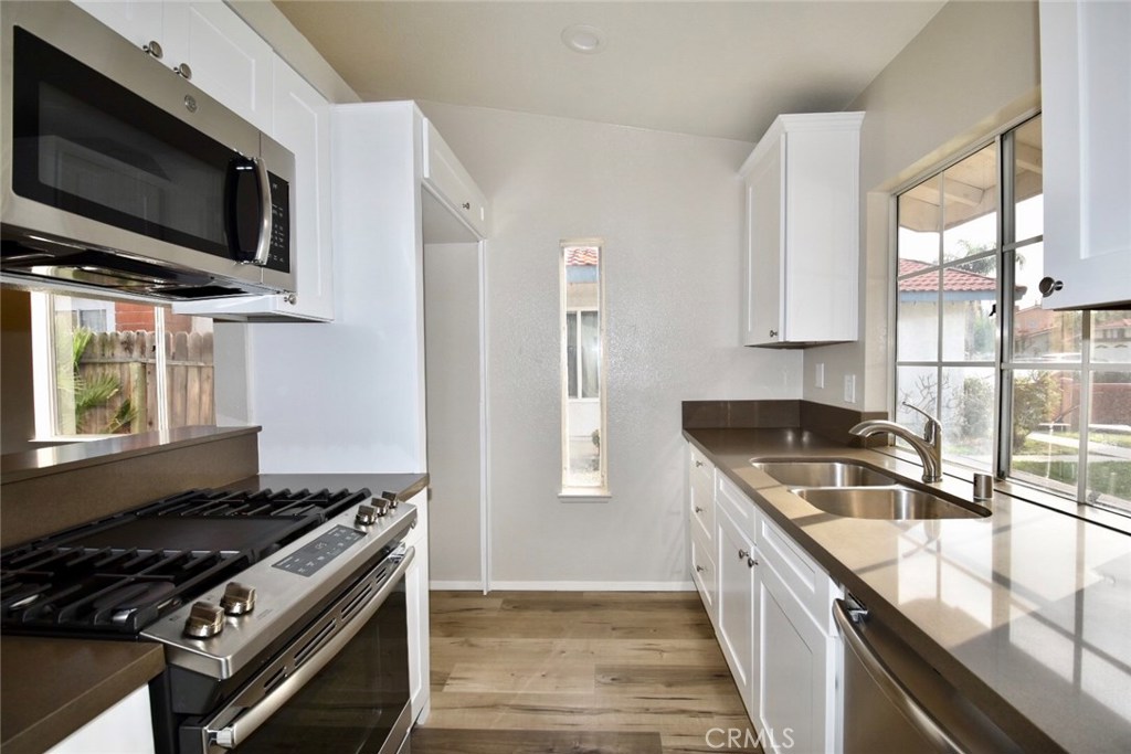 740 Atchison Street Colton, CA 92324 - Photo 5 of 15 a kitchen with stainless steel appliances granite countertop a sink stove and refrigerator