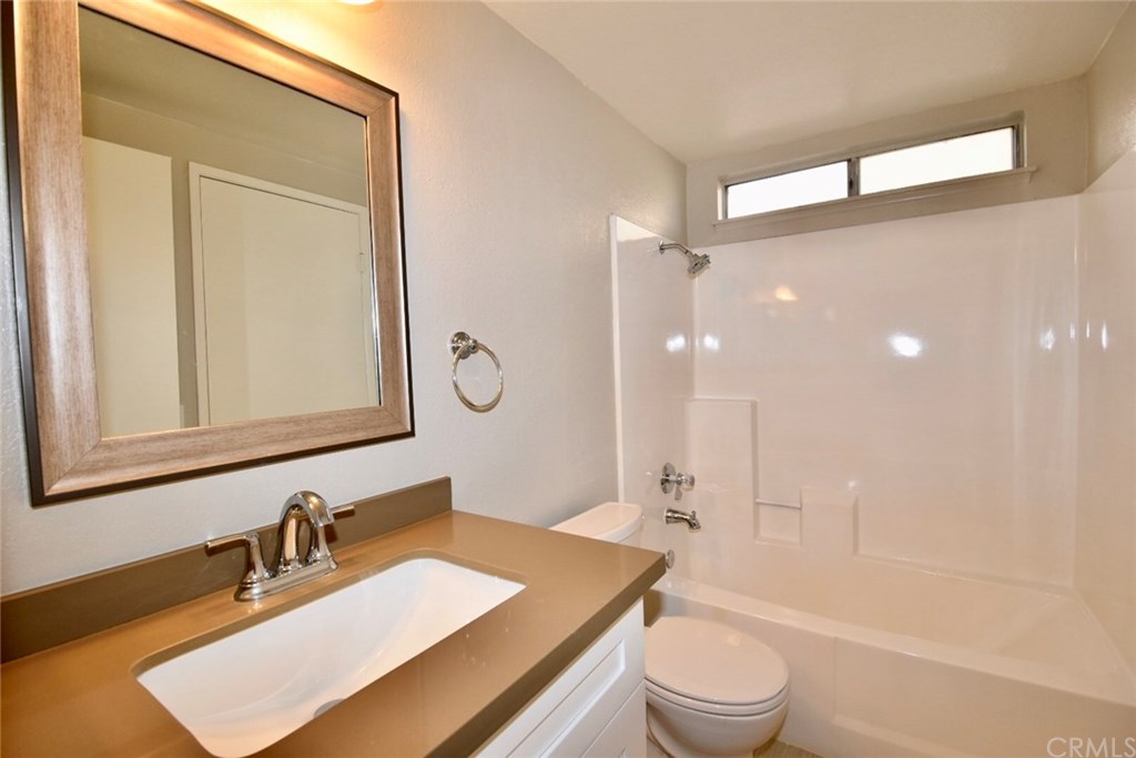740 Atchison Street Colton, CA 92324 - Photo 7 of 15 a bathroom with a granite countertop sink toilet a mirror and shower