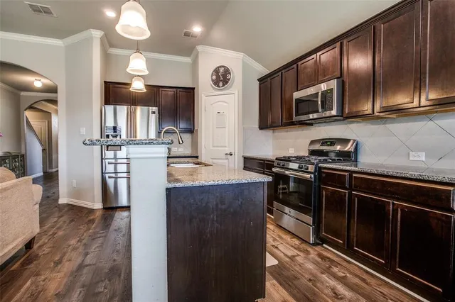 a kitchen with stainless steel appliances granite countertop a refrigerator a stove top oven a sink and dishwasher