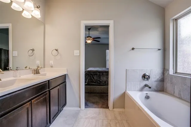 a bathroom with a tub sink and mirror