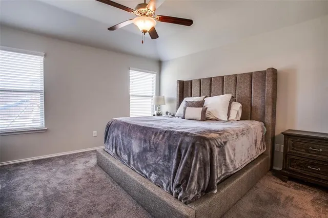 a spacious bedroom with a bed and a chandelier