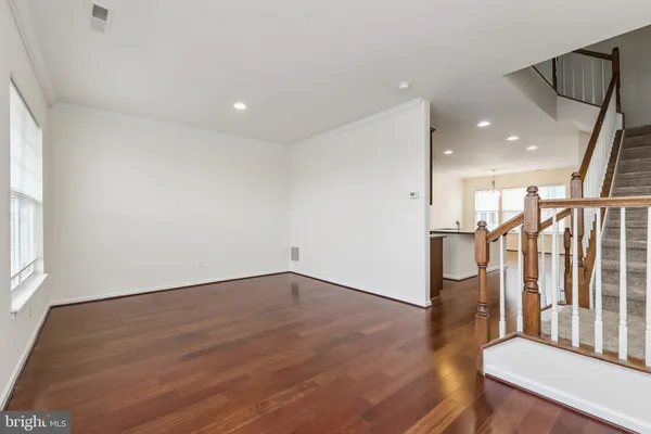 a view of an empty room with wooden floor