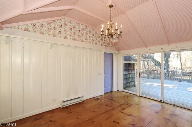 a view of a livingroom with a chandelier a ceiling fan and refrigerator