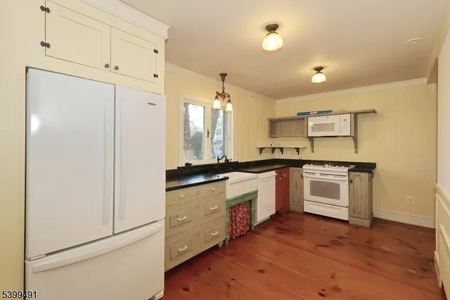 a kitchen with granite countertop white cabinets and white appliances