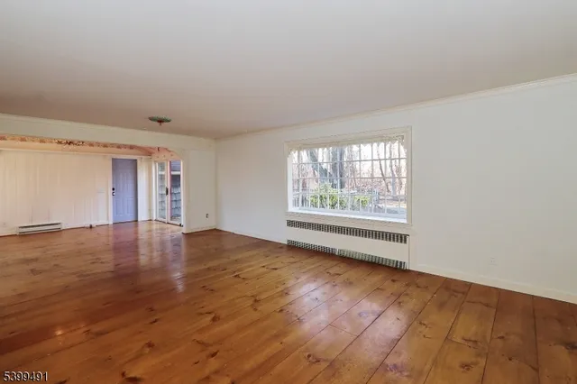 wooden floor in an empty room with a window