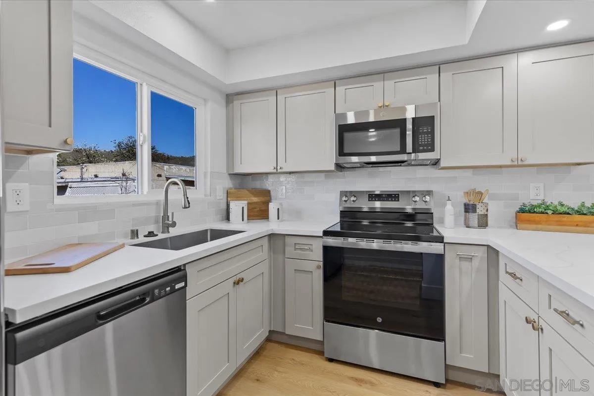 1572 Stone Edge Circle El Cajon, CA 92021 - Photo 11 of 34 a kitchen with stainless steel appliances granite countertop a sink dishwasher a stove and a microwave oven with cabinets