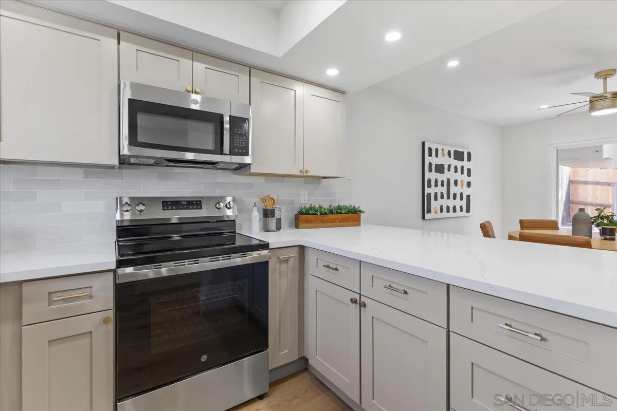 1572 Stone Edge Circle El Cajon, CA 92021 - Photo 12 of 34 a kitchen with white cabinets and stainless steel appliances