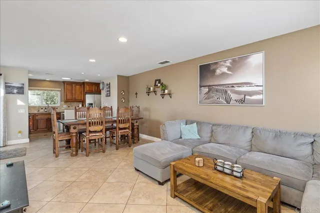 a living room with furniture and a dining table with kitchen view