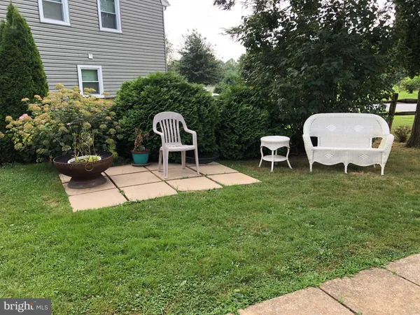 a view of a backyard with table and chairs potted plants and a garden