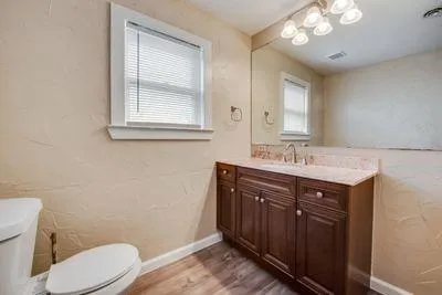 a bathroom with a sink vanity mirror and toilet