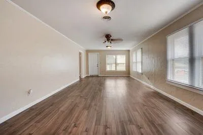 wooden floor in an empty room with a window
