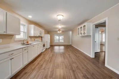 a large kitchen with cabinets wooden floor and stainless steel appliances