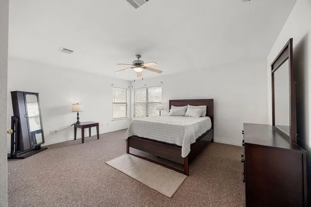 a spacious bedroom with a bed and a chandelier