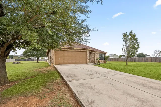 a front view of a house with a yard and trees