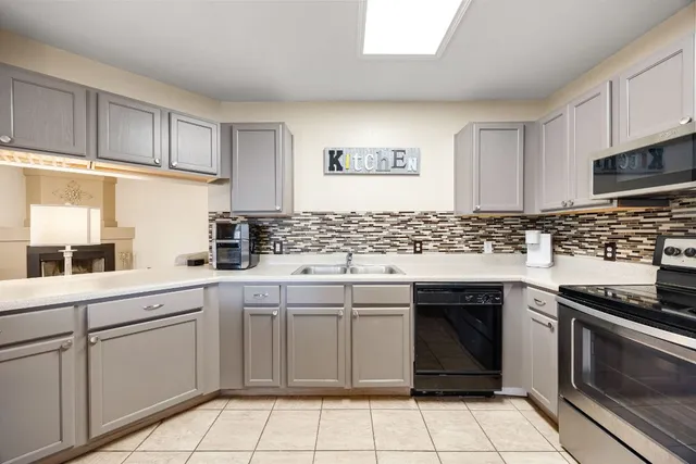 a kitchen with a sink stove top oven and cabinets