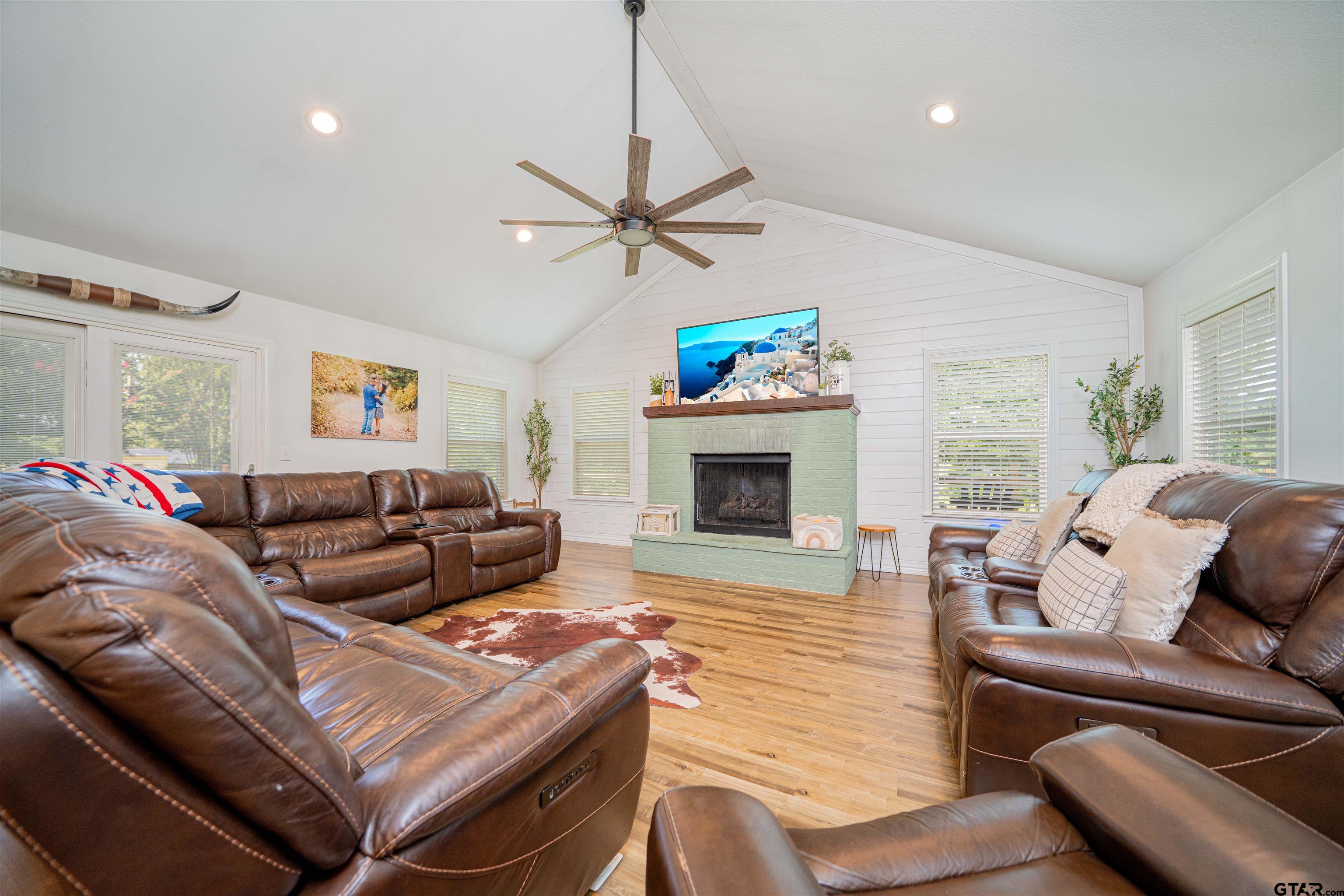 400 Crestview Hughes Springs, TX 75656 - Photo 11 of 32 a living room with furniture a fireplace and a flat screen tv