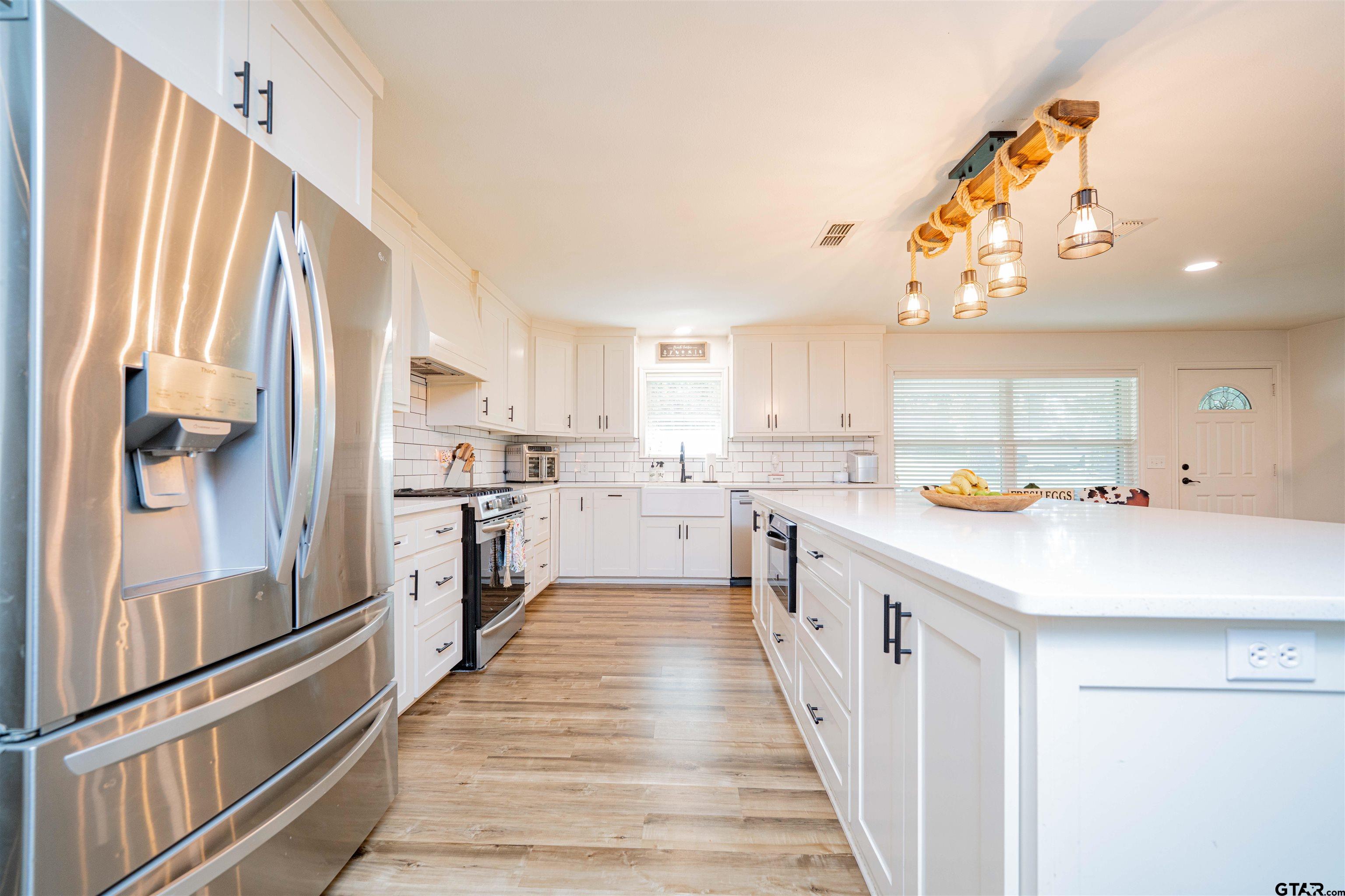 400 Crestview Hughes Springs, TX 75656 - Photo 6 of 32 a kitchen with stainless steel appliances a sink stove and refrigerator