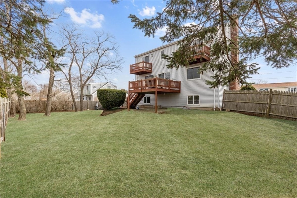 27 Packard Avenue Hull, MA 02045 - Photo 25 of 30 a view of a backyard with wooden fence and a bench