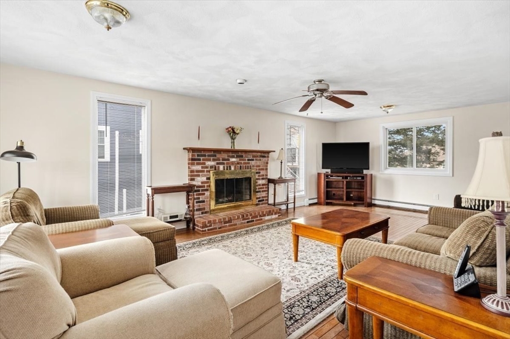 27 Packard Avenue Hull, MA 02045 - Photo 5 of 30 a living room with furniture a fireplace and a flat screen tv