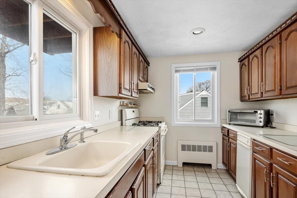 27 Packard Avenue Hull, MA 02045 - Photo 8 of 30 a kitchen with a sink stove and cabinets