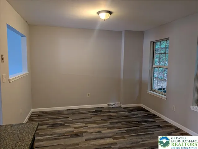 a view of room with window and wooden floor