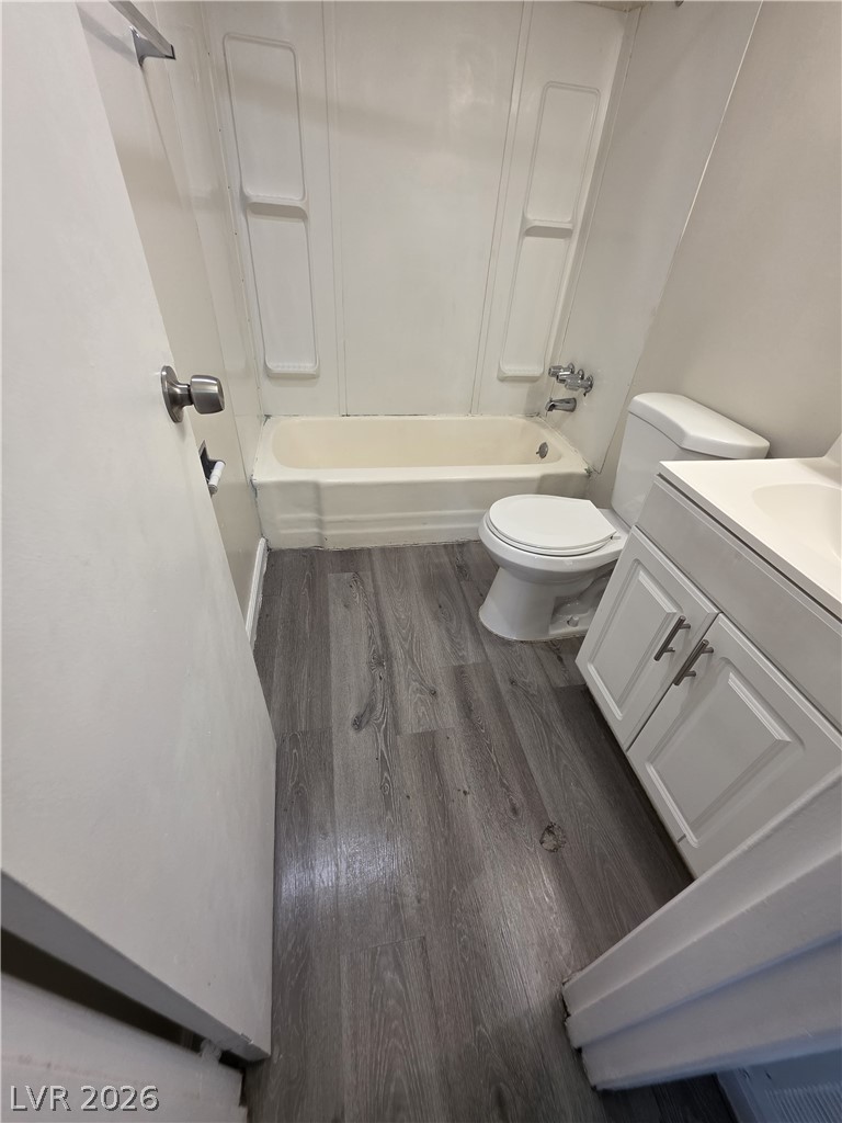 1075 East Desert Inn Road, Unit 5 Las Vegas, NV 89109 - Photo 7 of 12 A well-appointed bath features a tub-shower combination, vanity, and toilet with modern flooring.