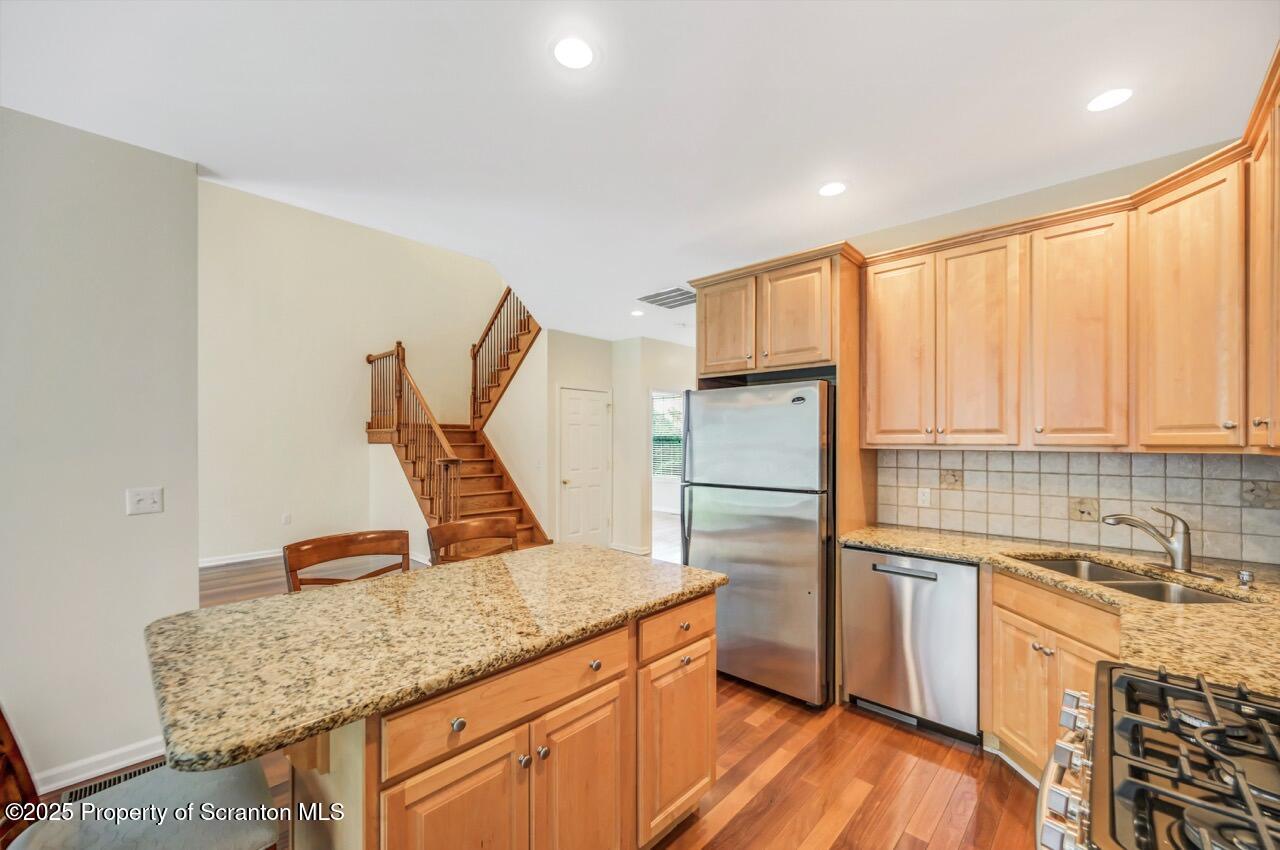 2303 Browning Cl Moosic, PA 18507 - Photo 20 of 71 a kitchen with stainless steel appliances granite countertop a sink dishwasher and a refrigerator with wooden cabinets