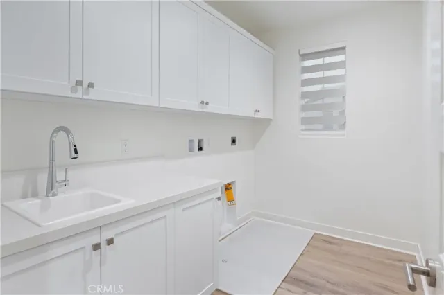 a utility room with sink dryer and washer