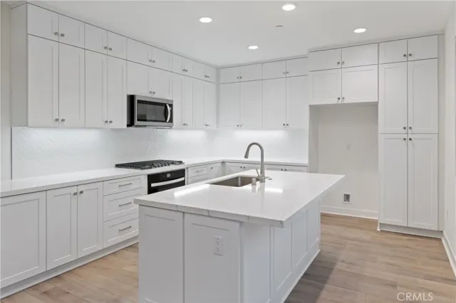 a kitchen with white cabinets and stainless steel appliances