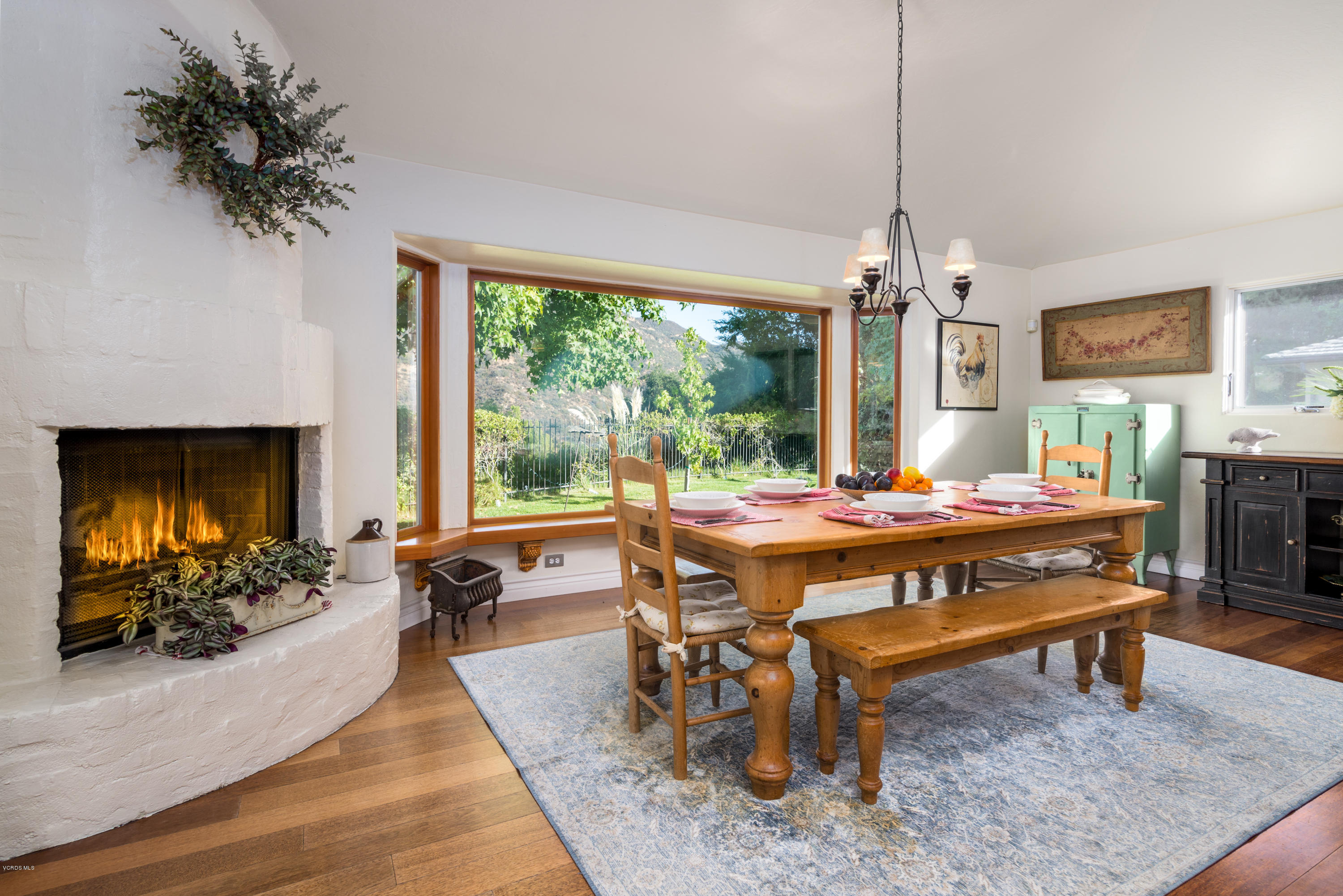 24353 Dry Canyon Cold Creek Road Calabasas, CA 91302 - Photo 21 of 36 a dining room with furniture a rug a fireplace and a chandelier