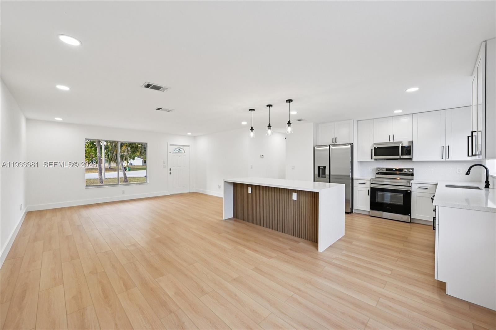 337 Southwest Cherryhill Road Port St. Lucie, FL 34953 - Photo 11 of 30 a large kitchen with stainless steel appliances kitchen island a large counter top and a stove top oven