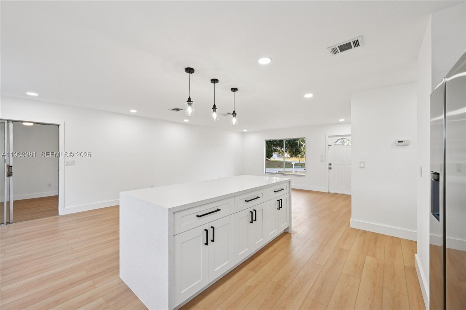 337 Southwest Cherryhill Road Port St. Lucie, FL 34953 - Photo 14 of 30 a kitchen with granite countertop a white refrigerator oven a sink and white cabinets with wooden floor