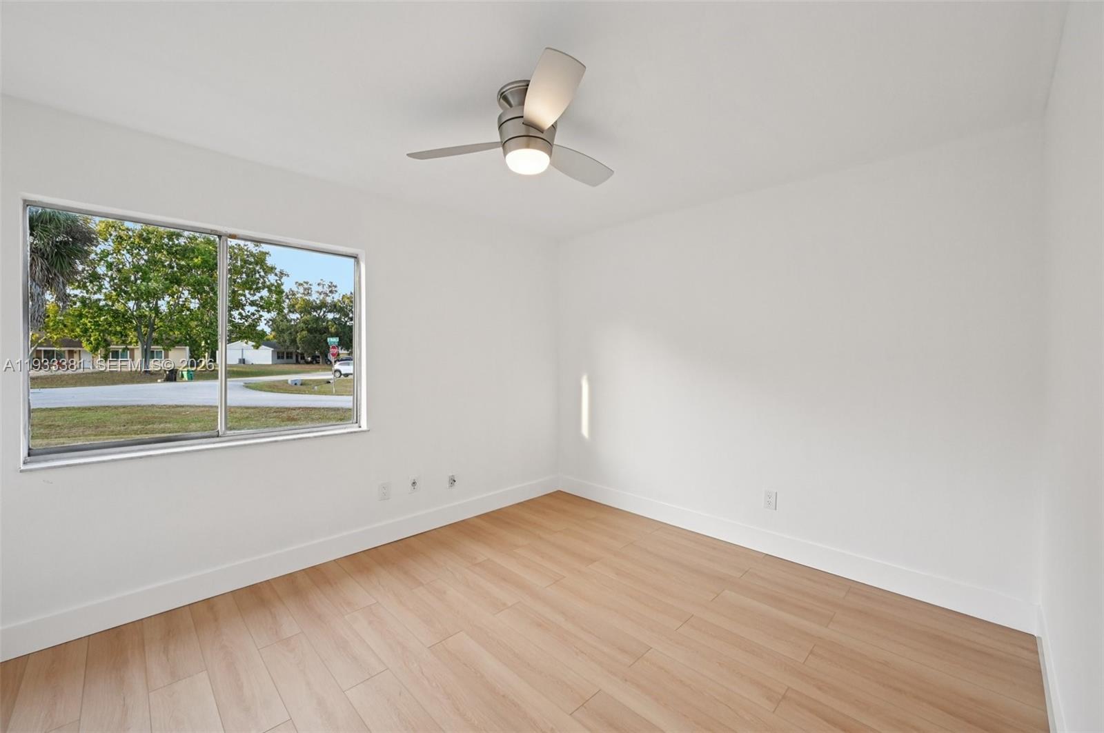 337 Southwest Cherryhill Road Port St. Lucie, FL 34953 - Photo 21 of 30 an empty room with wooden floor fan and windows
