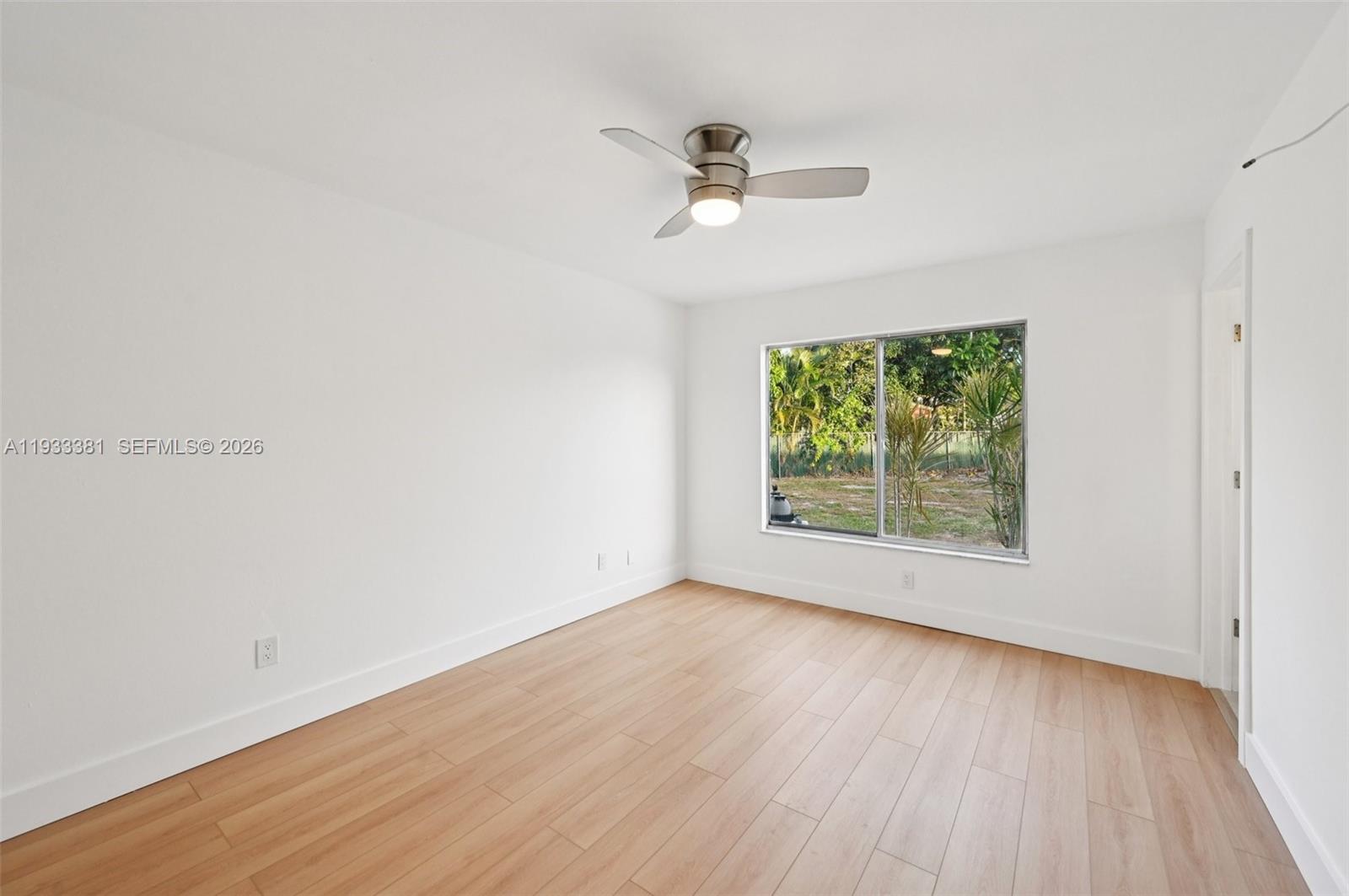 337 Southwest Cherryhill Road Port St. Lucie, FL 34953 - Photo 23 of 30 an empty room with wooden floor fan and windows