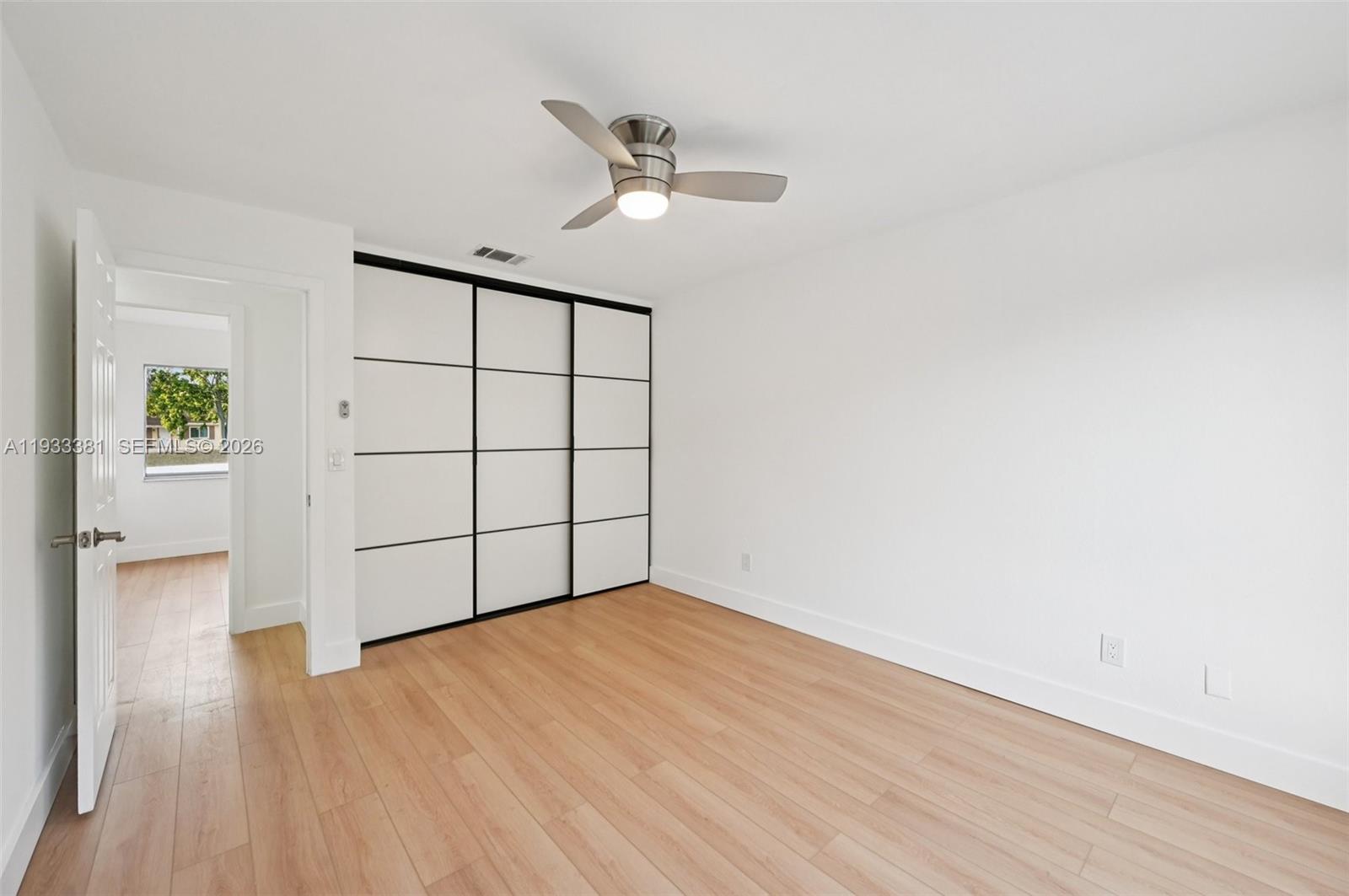 337 Southwest Cherryhill Road Port St. Lucie, FL 34953 - Photo 25 of 30 an empty room with wooden floor fan and windows