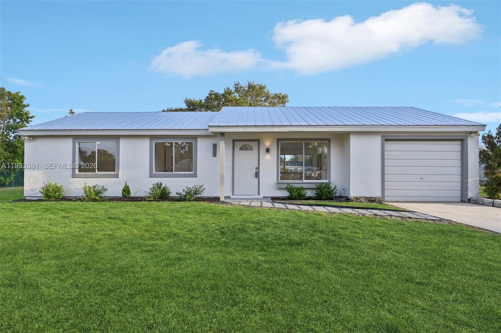 337 Southwest Cherryhill Road Port St. Lucie, FL 34953 - Photo 3 of 30 front view of a house with a yard
