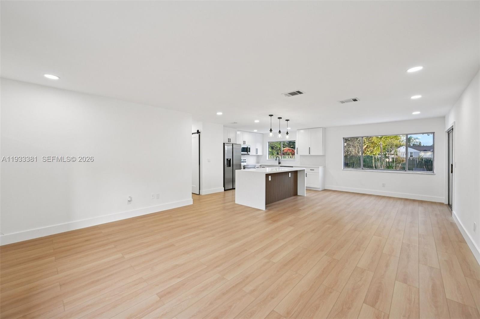 337 Southwest Cherryhill Road Port St. Lucie, FL 34953 - Photo 9 of 30 a view of an empty room with a window and wooden floor
