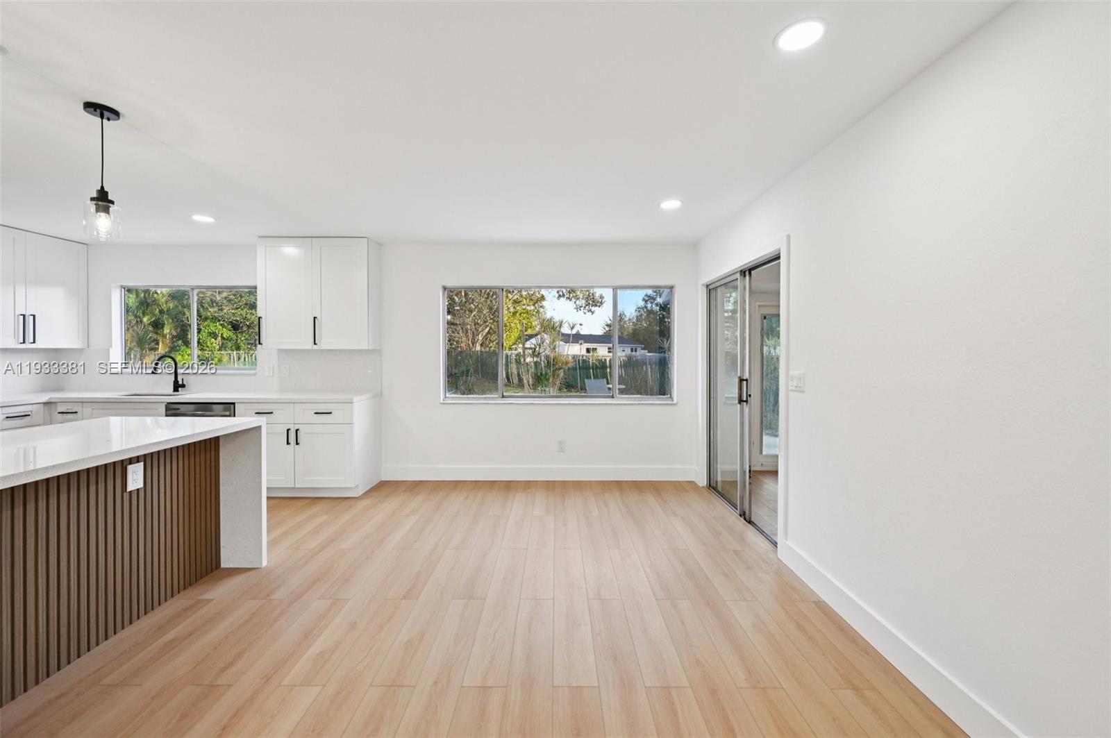 337 Southwest Cherryhill Road Port St. Lucie, FL 34953 - Photo 10 of 30 an empty room with wooden floor and windows
