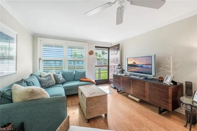 a living room with furniture a flat screen tv and a large window