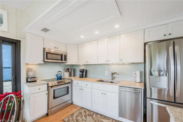 a kitchen with stainless steel appliances granite countertop a refrigerator sink and stove