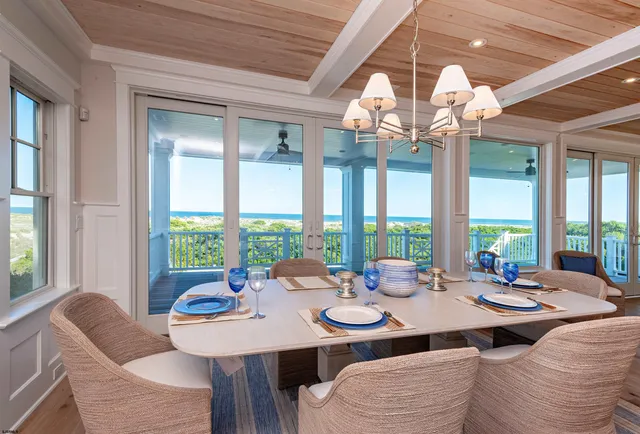 a view of a dining room with furniture large windows and wooden floor