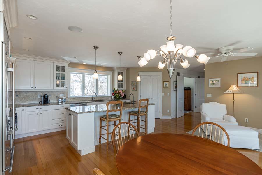99 Monomoscoy Road West Mashpee, MA 02649 - Photo 16 of 43 a kitchen with a dining table chairs stove and cabinets